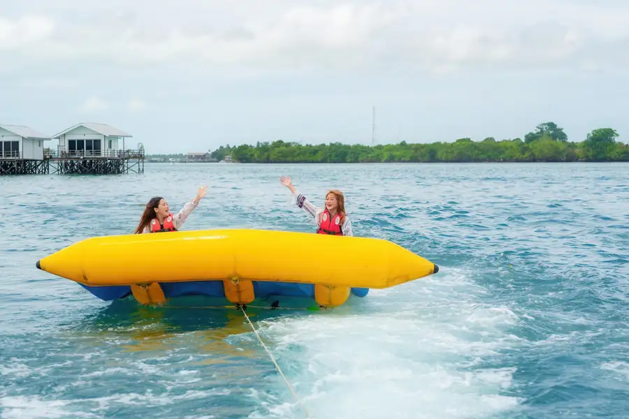 Guests enjoying a banana boat ride at the resort Noura Resort
