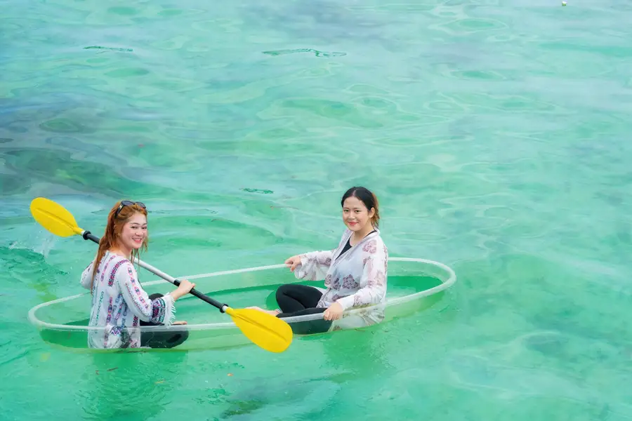 Guest enjoying a kayaking session at the overwater resort Noura Resort